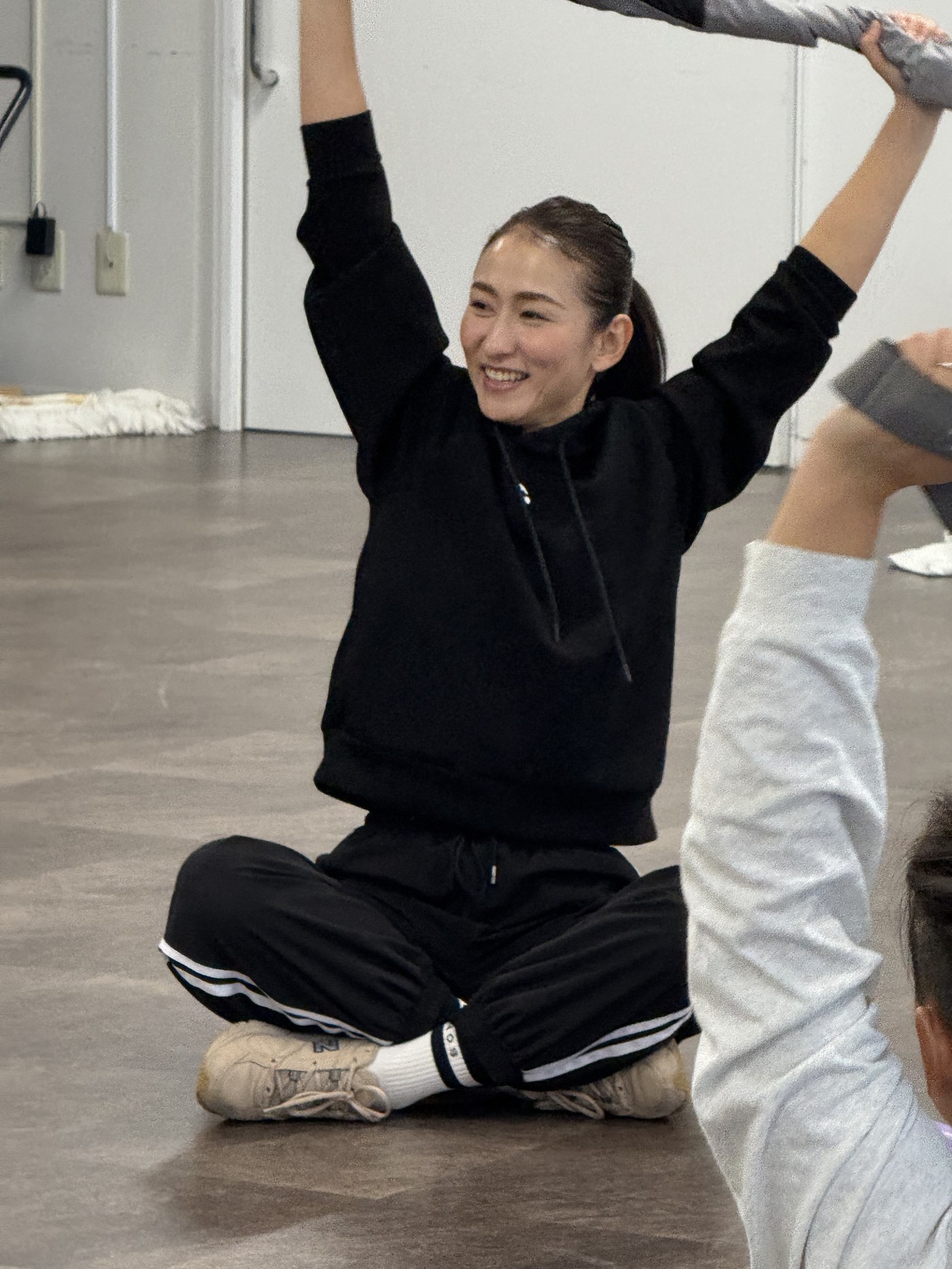 両手を上げて笑顔でレッスンをする三村逸美トレーナー